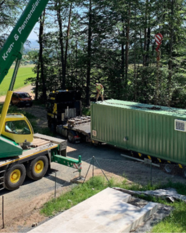Crane lifts water treatment container from lorry