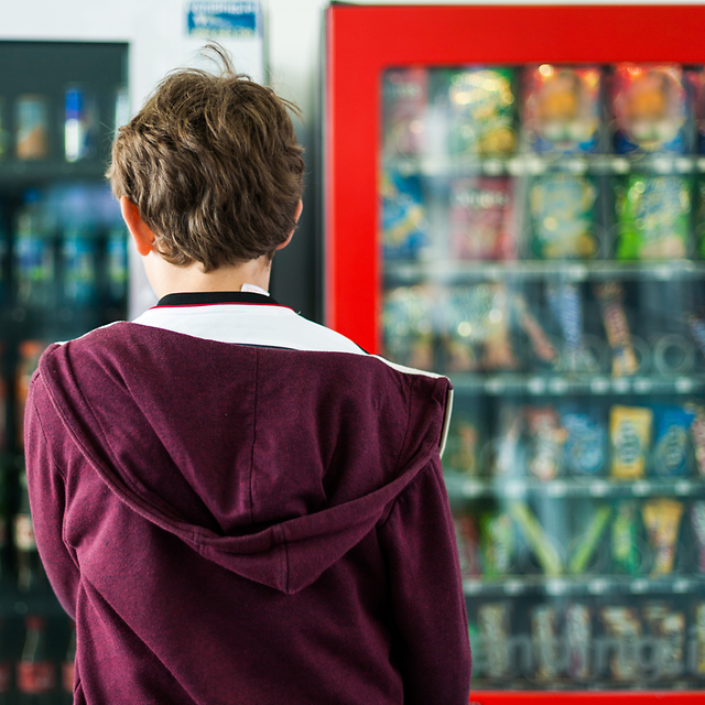 Kunde vor Getränke- und Snackautomaten
