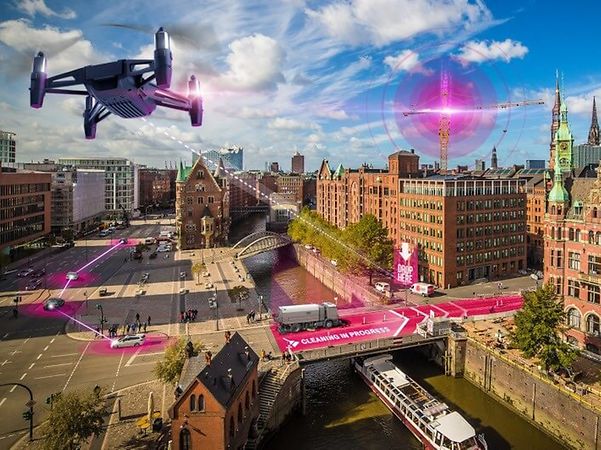 A drone flies over the city and uses Precise Positioning to locate autonomous machines with centimetre accuracy