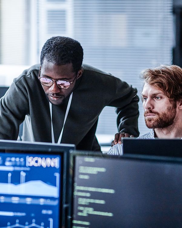 Two people in the office analyze IoT data on the computer
