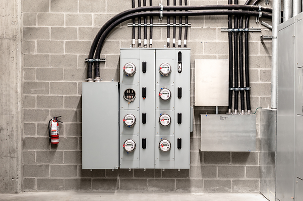 Row of electricity meters on a concrete wall.