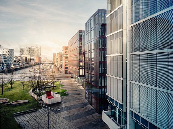 Modern buildings with glass facades and green spaces symbolize the future of smart building management