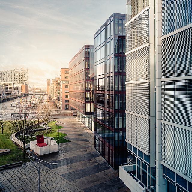 Moderna byggnader med glasfasader och grönområden symboliserar framtiden för smart fastighetsförvaltning