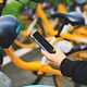 En person som låser upp en hyrcykel med hjälp av en smartphone-app.