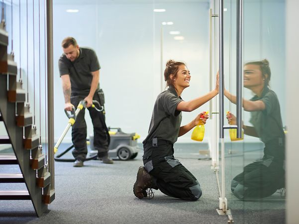 Los empleados de la empresa de limpieza están limpiando un pasillo del edificio de oficinas