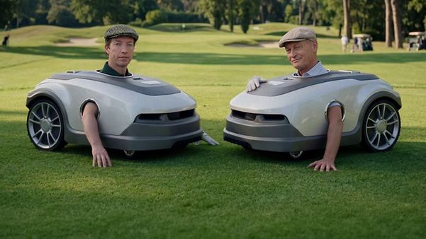 Two persons in lawn mower costumes on a golf court