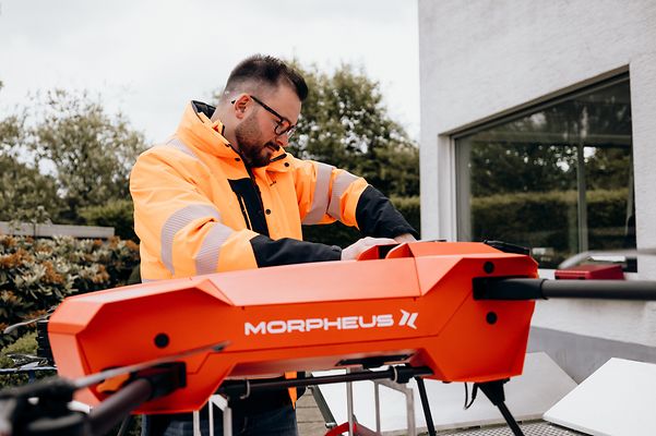 Techniker bereitet eine Morpheus-Transportdrohne vor einem Gebäude für den Einsatz vor.