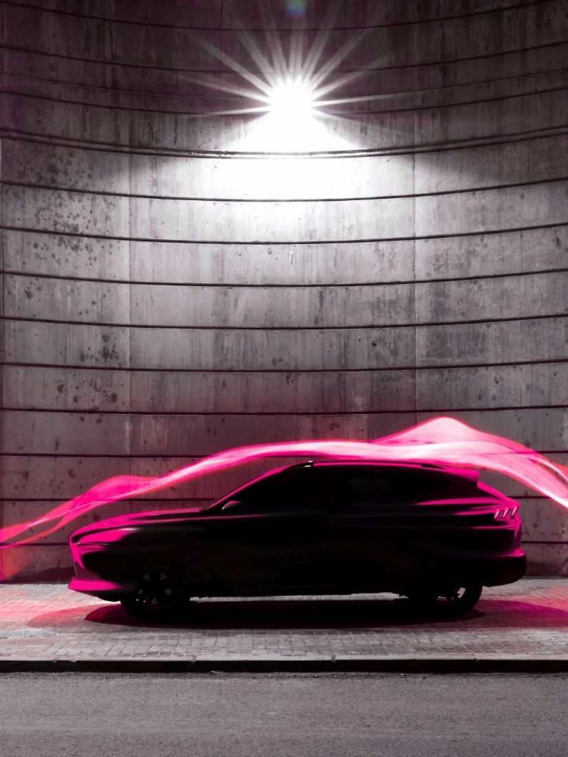 Schwarzes Auto unter Straßenlaternen mit pinken Lichtstreifen als Symbol für vernetzten Mobilität