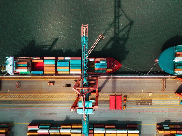 Frachtschiff im Hafen beim Beladen von Containern, unterstützt durch Telekom IoT für Nachverfolgung in Echtzeit