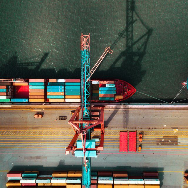 Frachtschiff im Hafen beim Beladen von Containern, unterstützt durch Telekom IoT für Nachverfolgung in Echtzeit