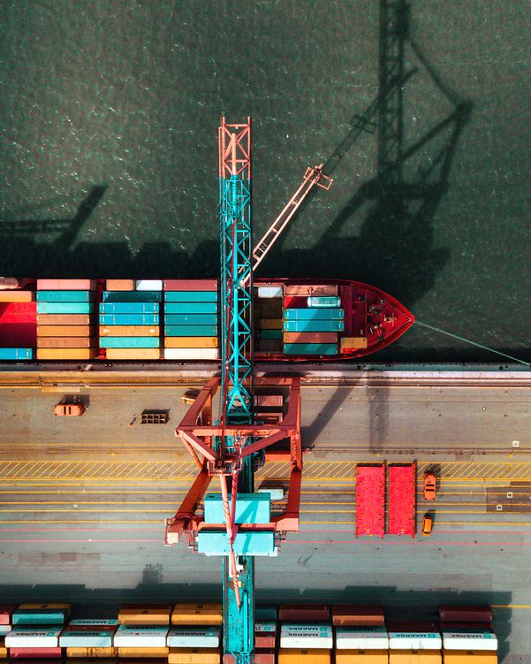 Frachtschiff im Hafen beim Beladen von Containern, unterstützt durch Telekom IoT für Nachverfolgung in Echtzeit