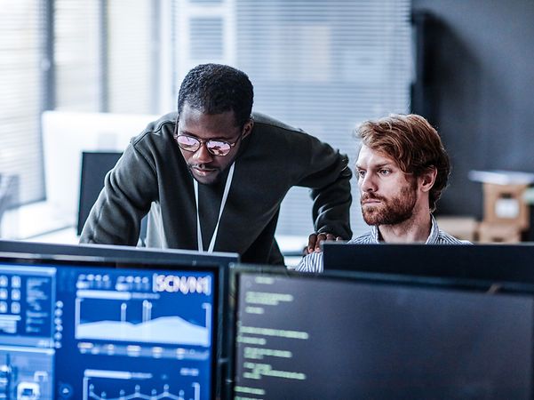 Zwei Personen im Büro analysieren IoT-Daten am Computer 