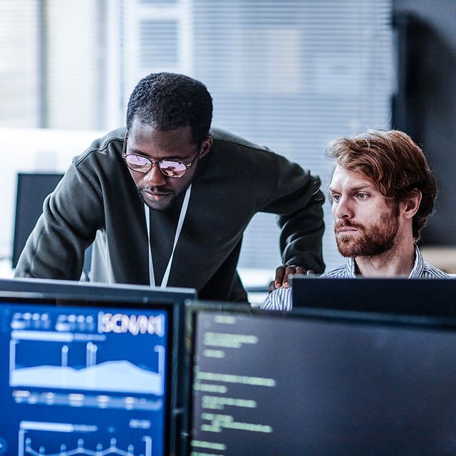 Zwei Personen im Büro analysieren IoT-Daten am Computer 