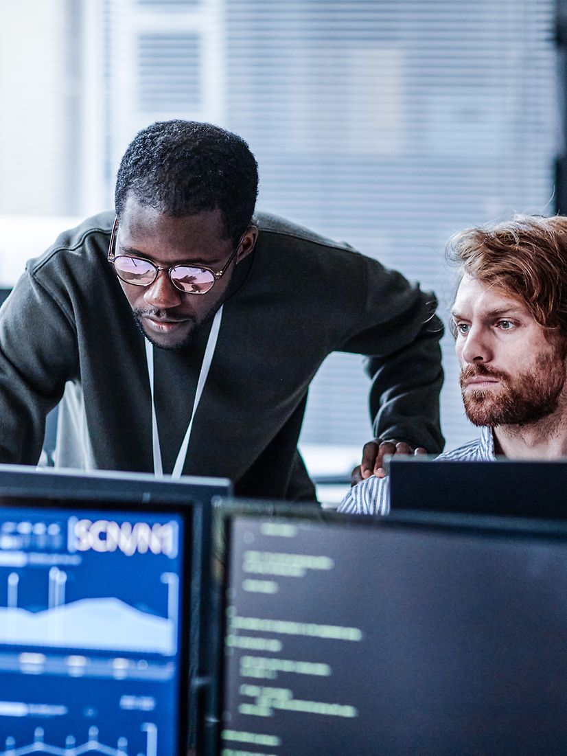 Zwei Personen im Büro analysieren IoT-Daten am Computer 