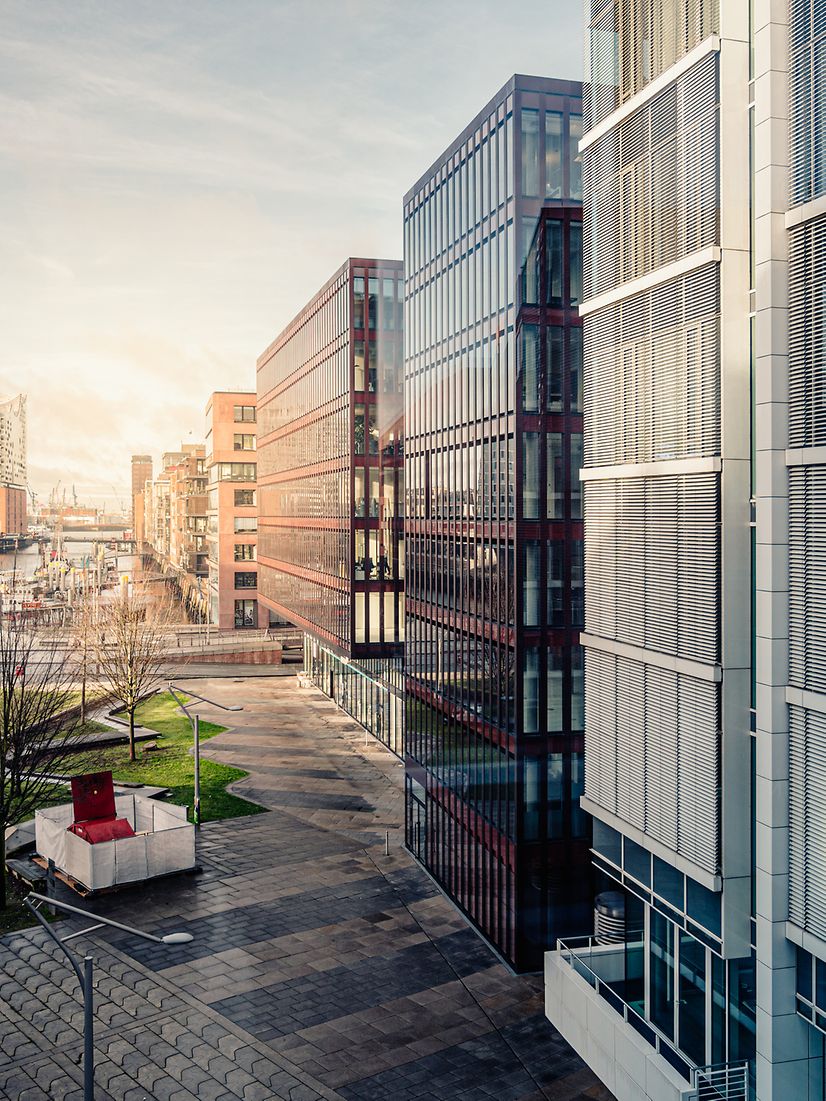 Moderne Gebäude mit Glasfassaden und Grünflächen symbolisieren die Zukunft der smarten Gebäudeverwaltung