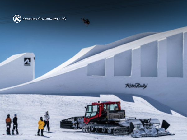 PistenBully von Kässbohrer mit Snowboardfahrern vor Kulisse der Nines