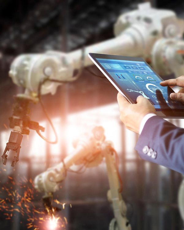 Person mit Tablet vor einer Produktionsanlage