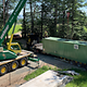 Kran hebt Wasseraufbereitungs-Container von LKW
