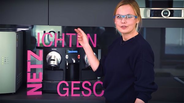 Frau mit Sicherheitsbrille zeigt auf Schrift "Netzgeschichten"