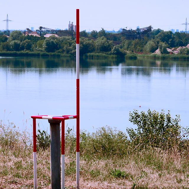 Messstelle zur Überwachung des Grundwasserspiegels und der Wasserqualität eines Baggersees.