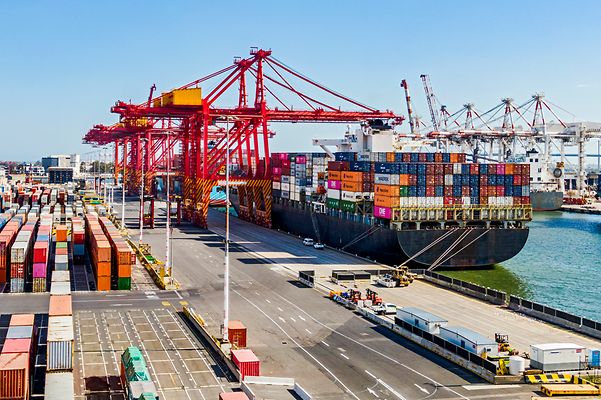 Ein Containerhafen mit einem Frachtschiff, das mit Containern beladen ist. 