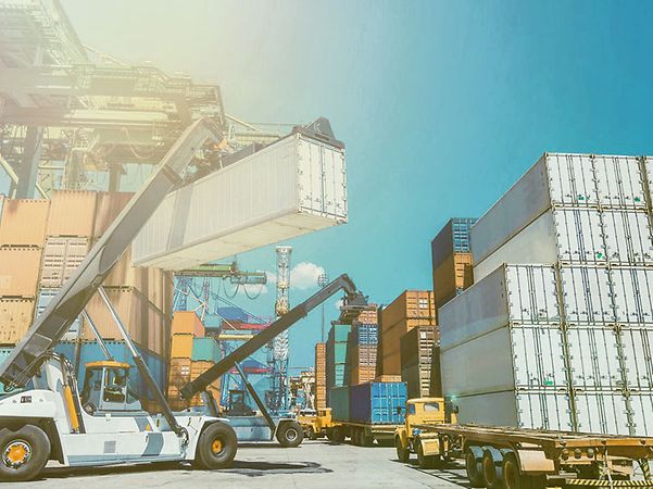 Ein Kran stapelt einen IoT-vernetzten Container auf einem Containerdepot