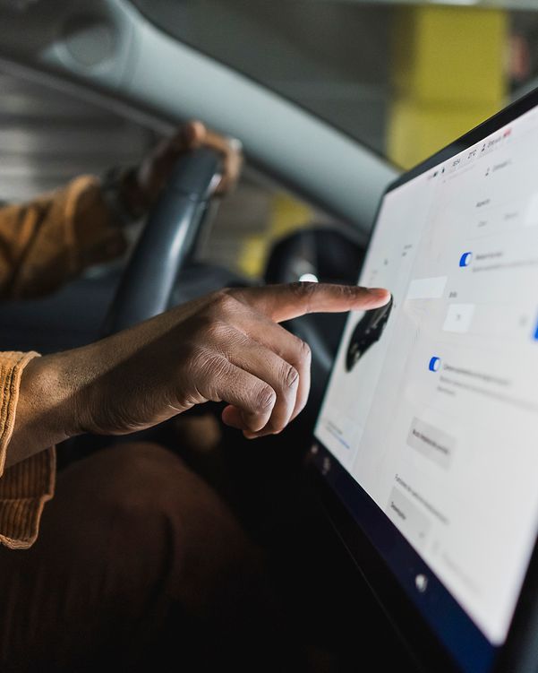 Fahrer bedient den Touchscreen eines modernen vernetzten Fahrzeugs.