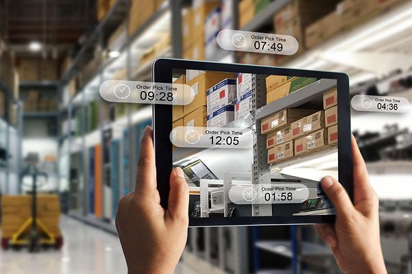 Blick auf ein Tablet mit verschiedenen Tracking-Daten von Waren in einem Logistikzentrum