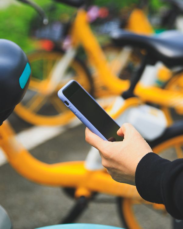 Person entsperrt ein Leihfahrrad per Smartphone-App.